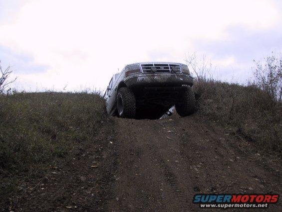 Ford F-Series truck going up a dirt hill, front wheels off the ground