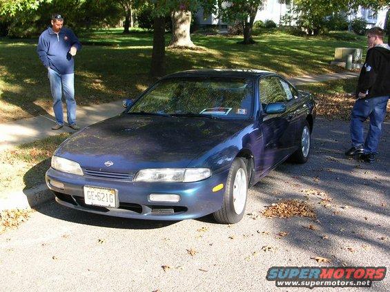Blue 1995 Nissan 240SX parked on asphalt with two men nearby