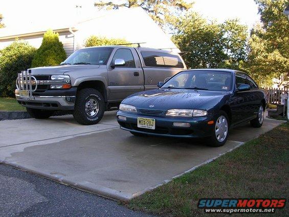 1995 Nissan 240SX parked next to a Chevrolet Silverado pickup truck