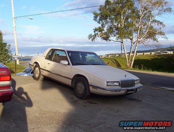 White 1986 Buick Riviera coupe parked on gravel lot