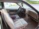 1995 Ford Crown Victoria - The interior of a 1989 Buick Riviera shows tan velour seats and wood grain accents.