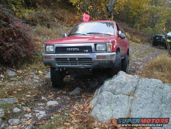 Red Toyota 4Runner off-roading over rocks