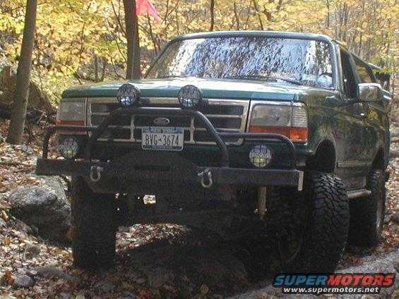 Green 1992 Ford Bronco with off-road bumper and lights