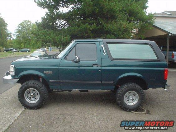 Green 1993 Ford Bronco with black hardtop, lifted suspension, and aftermarket wheels parked on a street