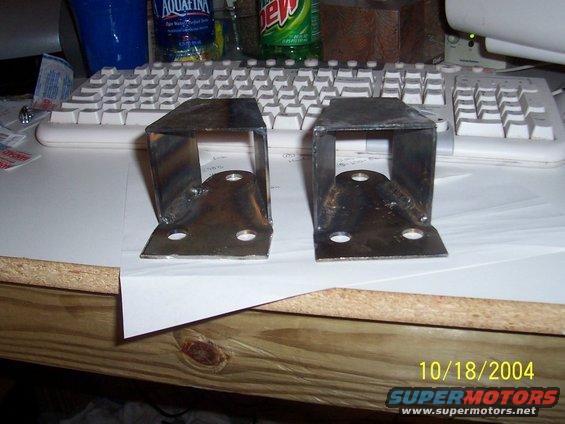 Two welded metal brackets with four mounting holes each