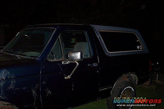 Side view of dark blue SUV with a hardtop and visible tire text