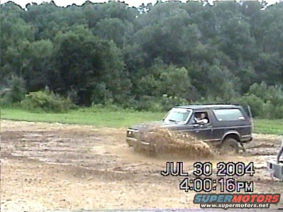 Dark SUV splashing mud, 3/4 front view. Visible timestamp: JUL 30 2004 4:00:16PM