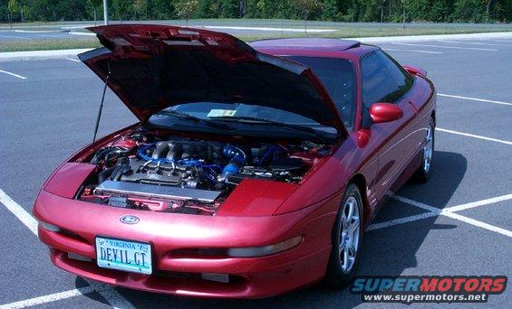 Red 1996 Ford Probe with the hood open, showing the engine bay. License plate says 'DEVIL GT'