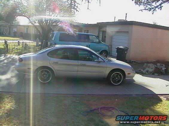 Silver 1999 Ford Taurus sedan parked in driveway, side view