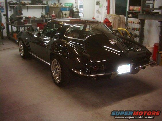 Black coupe with chrome trim and aftermarket wheels