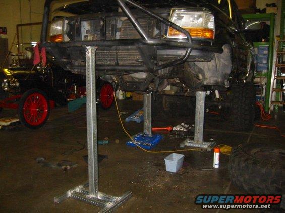 1992 Ford Bronco front end raised on shop lifts, showing suspension and engine bay
