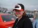 1987 Ford Bronco - A woman poses for a photo at what appears to be a car event with other people and vehicles in the background.