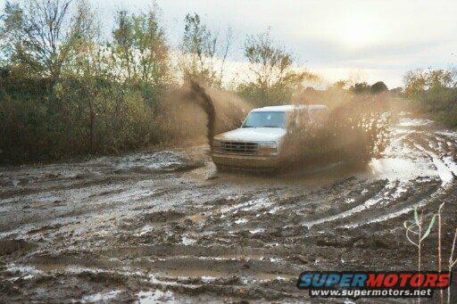 1993 Ford Bronco splashing through a muddy track
