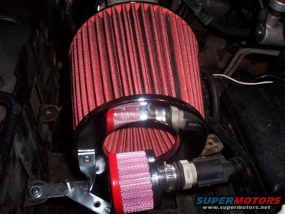 Engine bay with two red air filters and chrome piping