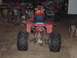 1995 Mercury Grand Marquis - This red ATV has flame decals and is parked in a garage next to another vehicle.
