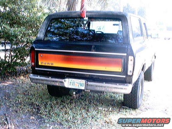 Black 1978 Ford Bronco rear view with orange and yellow stripe on tailgate