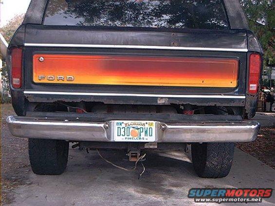 Black 1978 Ford Bronco rear view with orange and red tailgate panel and chrome bumper