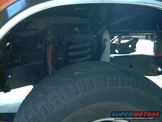 Tire and suspension components of a vehicle, showing a coil spring and shock absorber