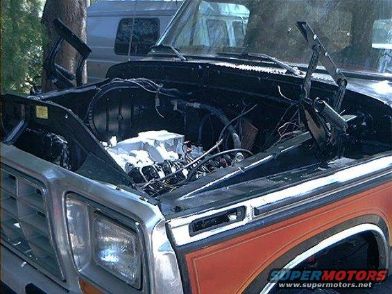 Ford truck with hood open, showing engine. Another vehicle is visible behind it