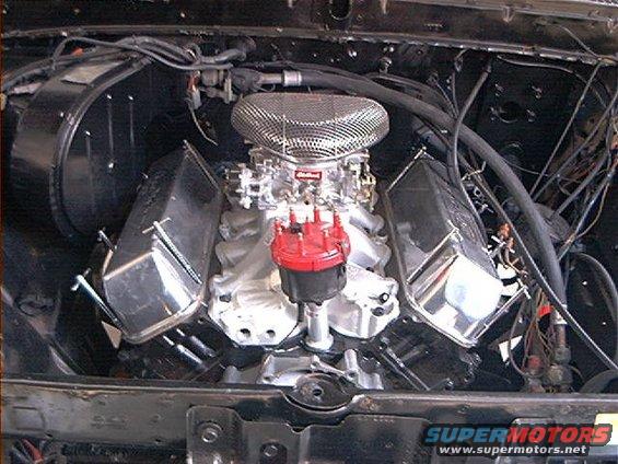 Engine bay showing a V8 engine with chrome valve covers and a large air cleaner