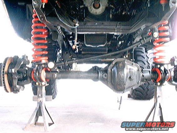 vehicle's rear axle and suspension components are visible, supported by jack stands