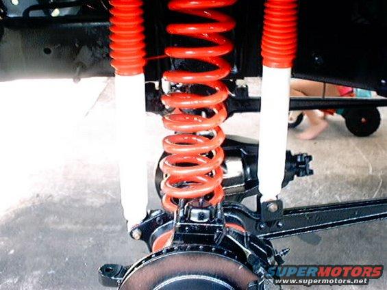 Front suspension with red coil springs and white shock absorbers