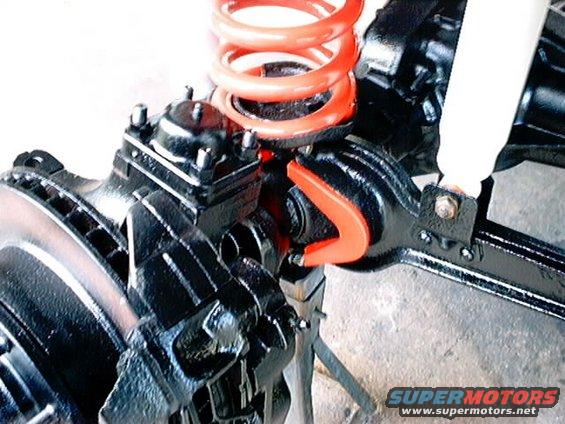 Front suspension assembly with red coil spring and black brake caliper