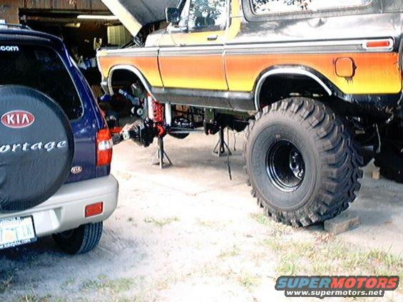1979 Ford Bronco side view, orange and yellow stripes, lifted with hood open