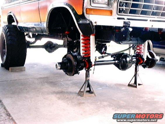 Ford Bronco front end lifted on jack stands, showing suspension and axles