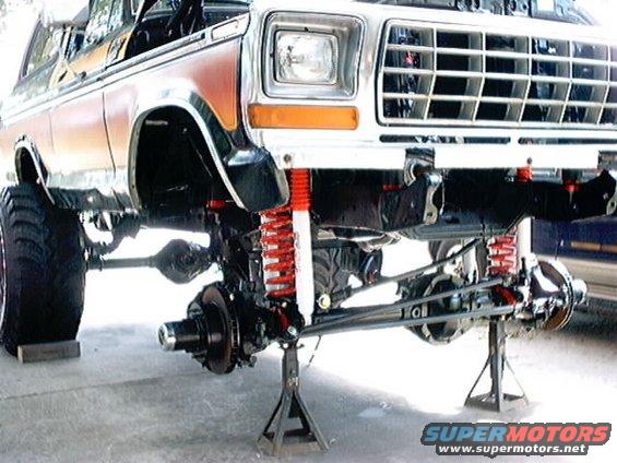 1978 Ford Bronco front end lifted on jack stands, showing suspension and chassis modifications