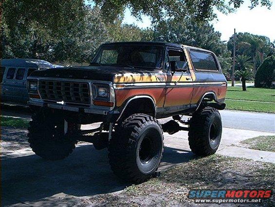 Lifted 1979 Ford Bronco with orange and yellow stripes, large off-road tires