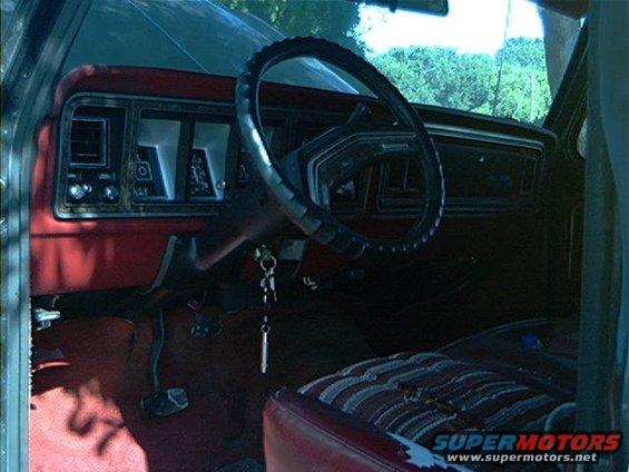 1979 Ford Bronco interior showing dashboard, steering wheel, and striped seat