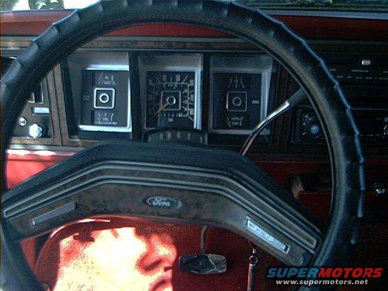 Dashboard view of a Ford truck or SUV, showing steering wheel, gauges, and 'Ford' logo on the steering wheel