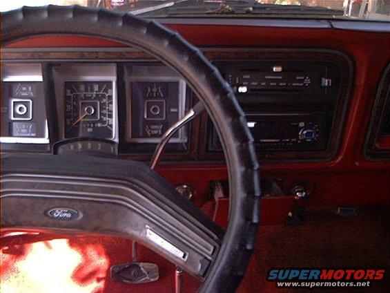 1979 Ford Bronco interior showing dashboard with gauges, steering wheel with Ford logo, and radio