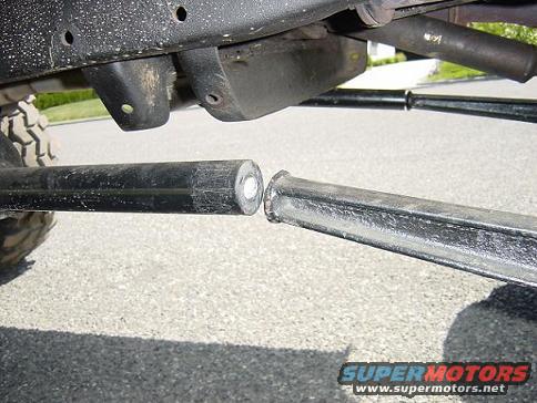 close-up of two metal suspension linkage bars disconnected