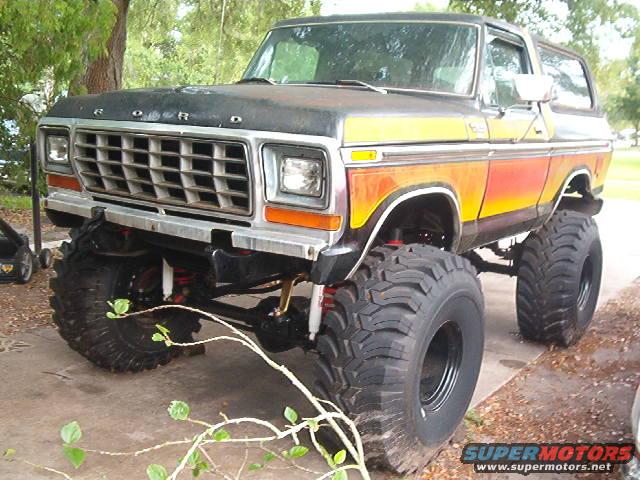 Black and orange lifted 1978 Ford Bronco with large tires, front view