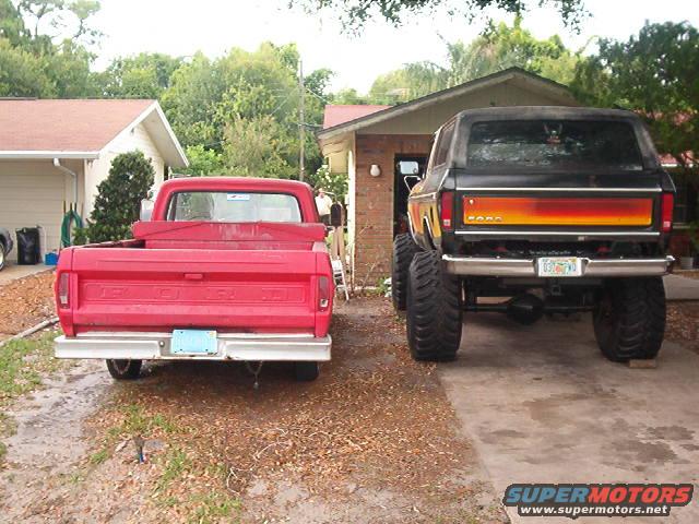 Black lifted 1979 Ford Bronco rear view with orange and yellow tailgate stripe