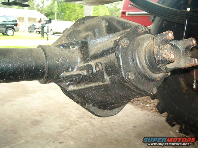 Black rear axle differential with driveshaft attached, showing rust on U-joint