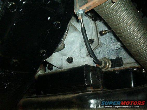 Engine part with black box and sensor, Supermotors.net logo visible