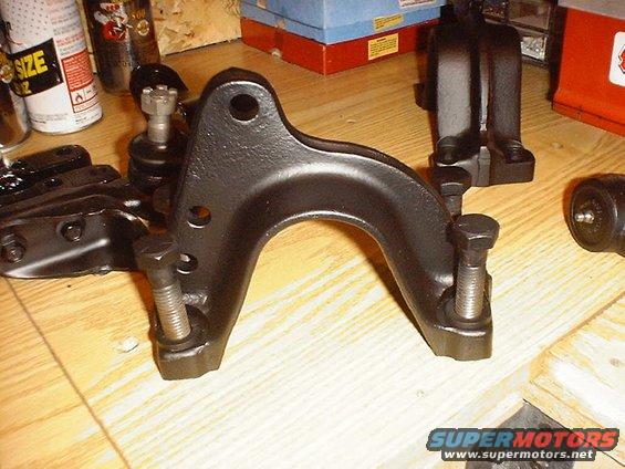 Black painted metal front axle component with bolts and ball joint