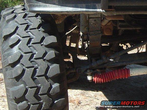 Close-up of a large off-road tire and red shock absorber