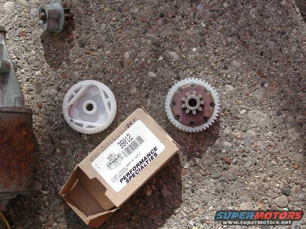 automotive parts including a starter motor, gears, and a box labeled 'PERFORMANCE SPECIALTIES 38012' on concrete