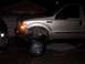 2000 Ford F-450 - This gold Ford F-450 pickup truck is shown in a 3/4 front view, highlighting its lifted suspension.