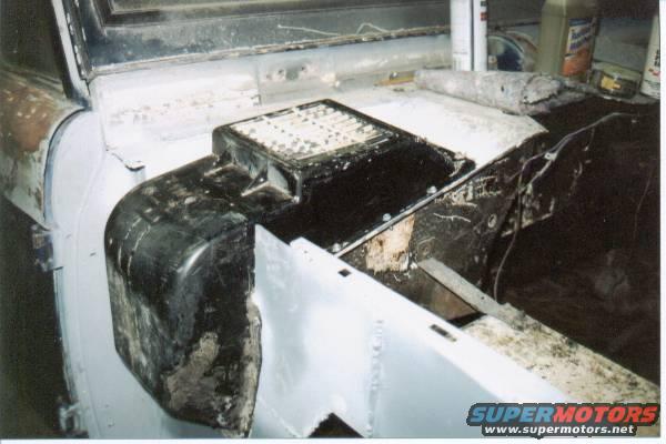 Vehicle interior showing unfinished dashboard and fender area with black plastic components