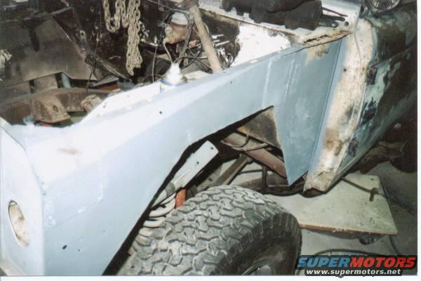 vehicle bodywork being repaired, showing fender and tire