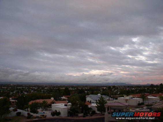 Overcast sky above suburban houses and distant mountains