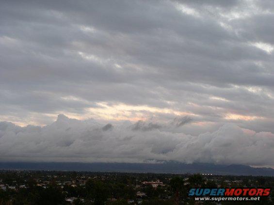 Stormy sky over a city with Supermotors logo