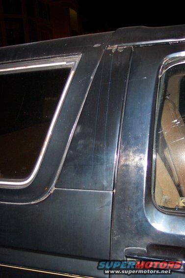 Dark blue SUV body panel with chrome trim around window and door handle