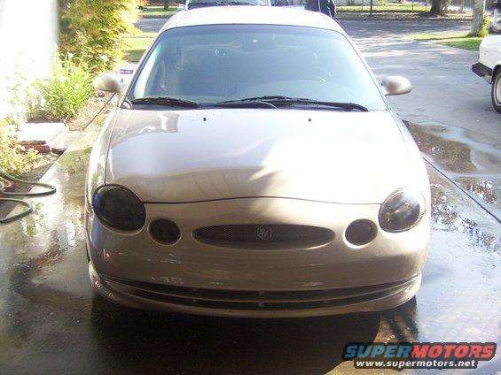 Front view of a tan Mercury Sable sedan. The grille has the Mercury emblem