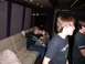 1990 Ford Bronco - A young man sits on a plush couch inside a vehicle, holding a beverage and waving to the camera.